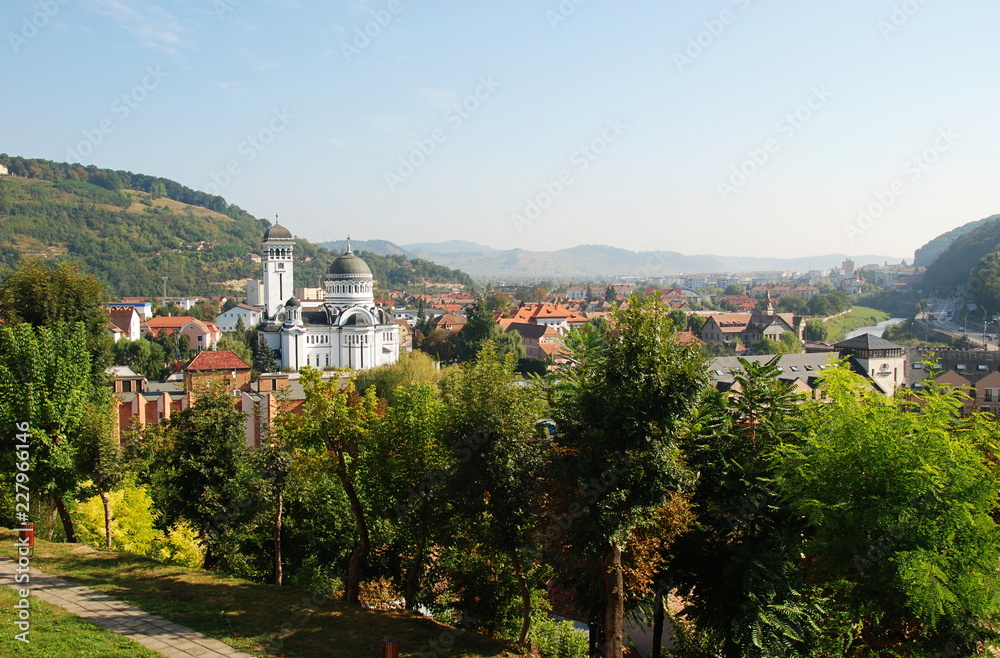 Sighisoara cityscape with Holy Trinity Orthodox Church and view of Carpathian Mountains, Romania
