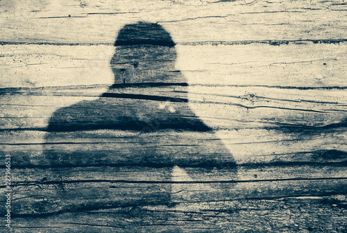 Man photographer shadow on old wooden logs wall