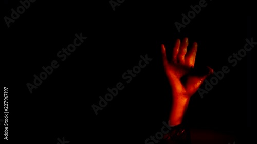 BABY DOLL HAND REACHES UPWARD FROM THE DARKNESS, IN 4K photo