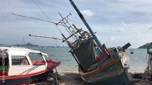 Fishing boats in the harbor. Shipwreck on the beach. An old wrecked wooden boat near the shore with the beach.