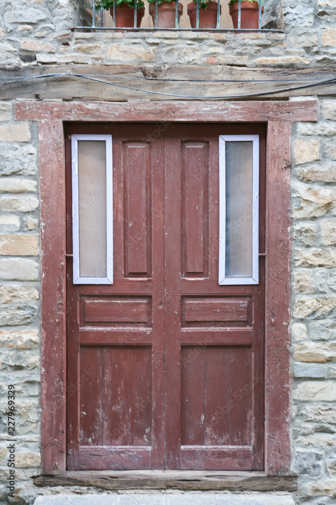 Old wooden entrance door of a stone house