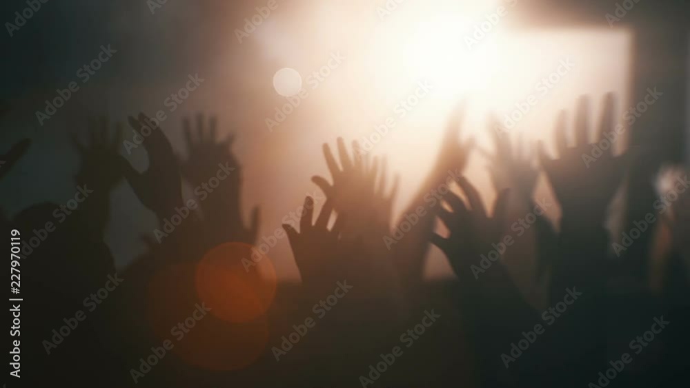 Silhouettes of hands raised in worship with light rays and Cross. Silhouettes of hands raised in worship with light rays and Cross.