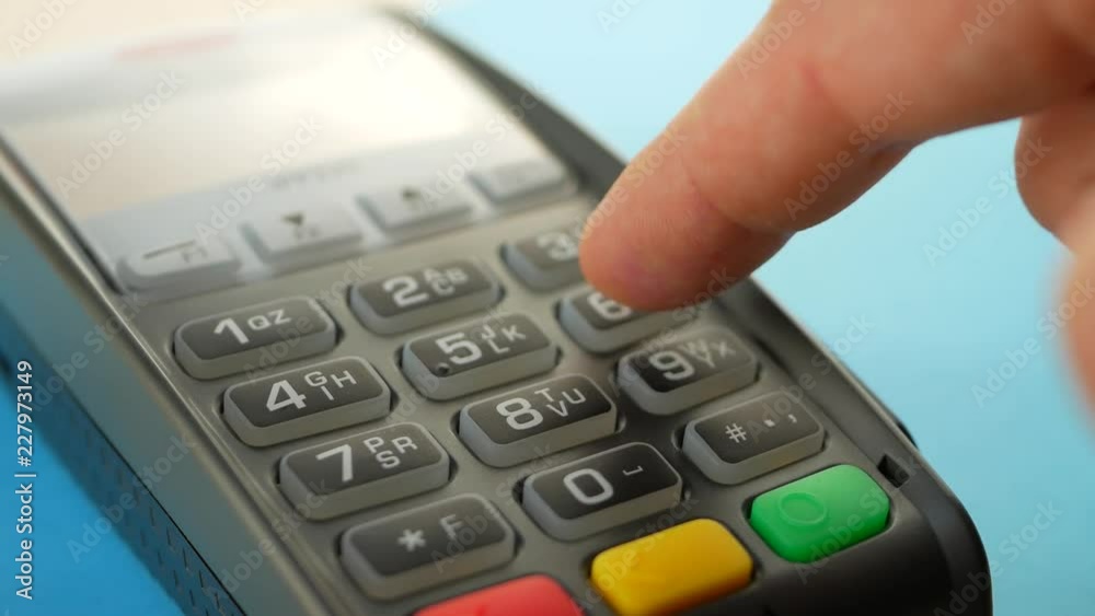 Credit card reader machine at bar counter with male holding credit card. Hand of customer paying with contactless credit card with NFC technology on blue background. Finger entering the PIN code Credit card reader machine at bar counter with male holding credit card. Hand of customer paying with contactless credit card with NFC technology on blue background. Finger entering the PIN code