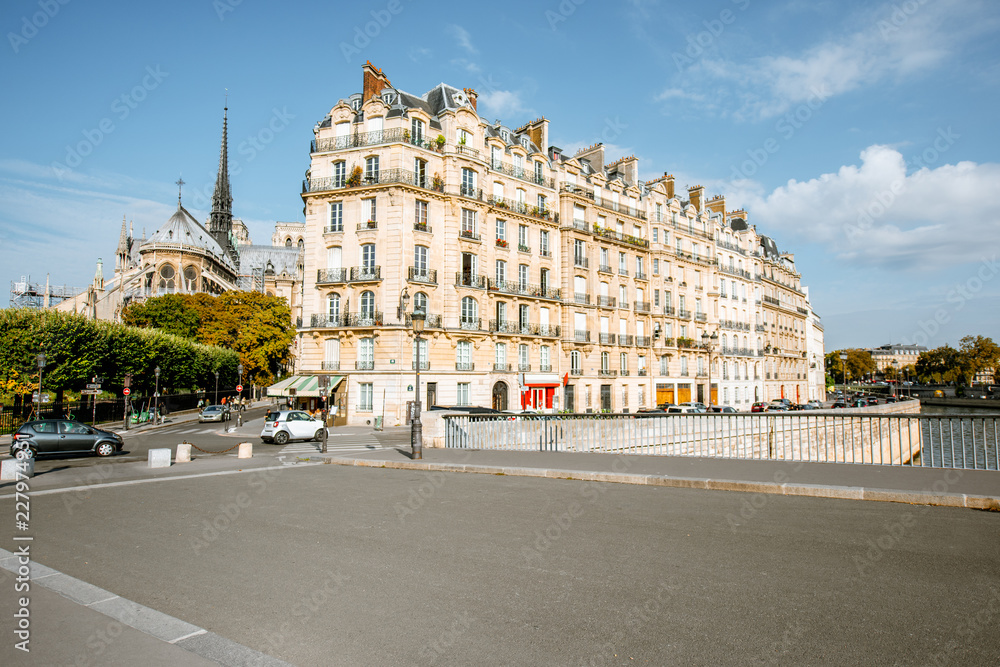 Fototapeta premium Street view with beautiful buildings and cafe terrace during the morning light in Paris