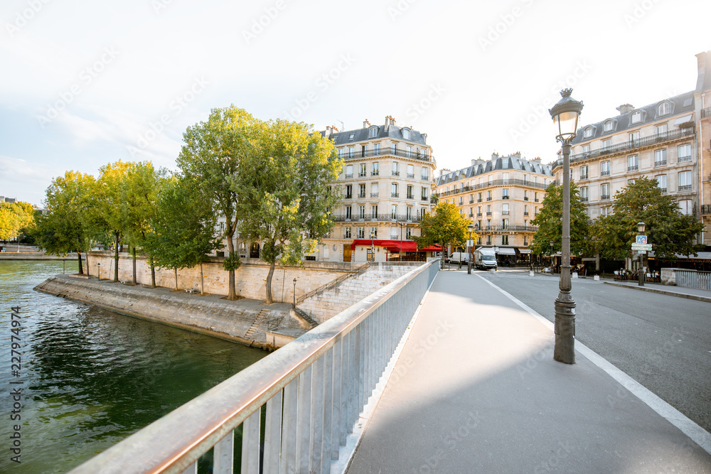 Street view with beautiful buildings and cafe terrace during the morning light in Paris