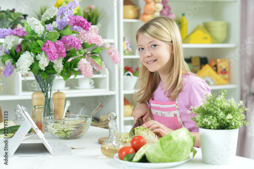 Portrait of a cute little girl cutting cabbage