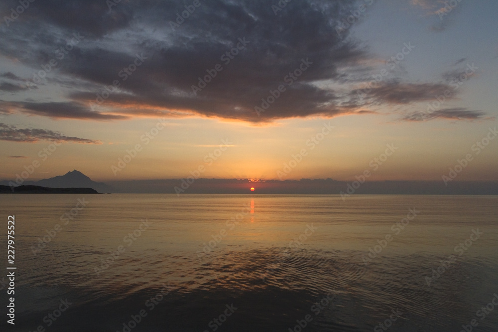 Silhouette of mount Athos at sunrise or sunset with light rays and sea panorama in Greece