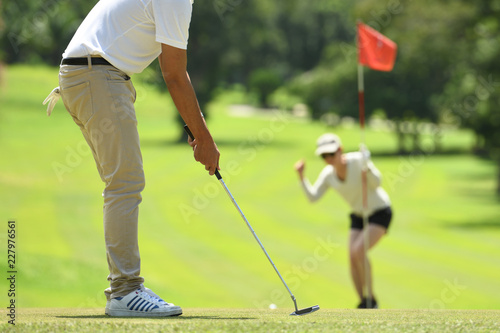  Man and woman playing golf on a beautiful natural golf course