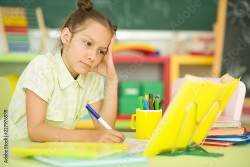 Portrait of a cute girl doing homework