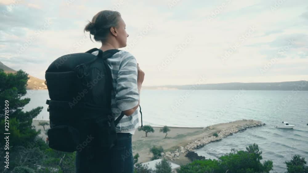 Woman with backpack near the sea coast. Woman with backpack near the sea coast.