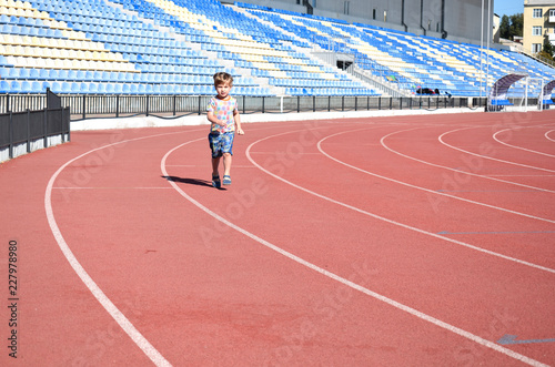 Little boy on the treadmill at the stadium.