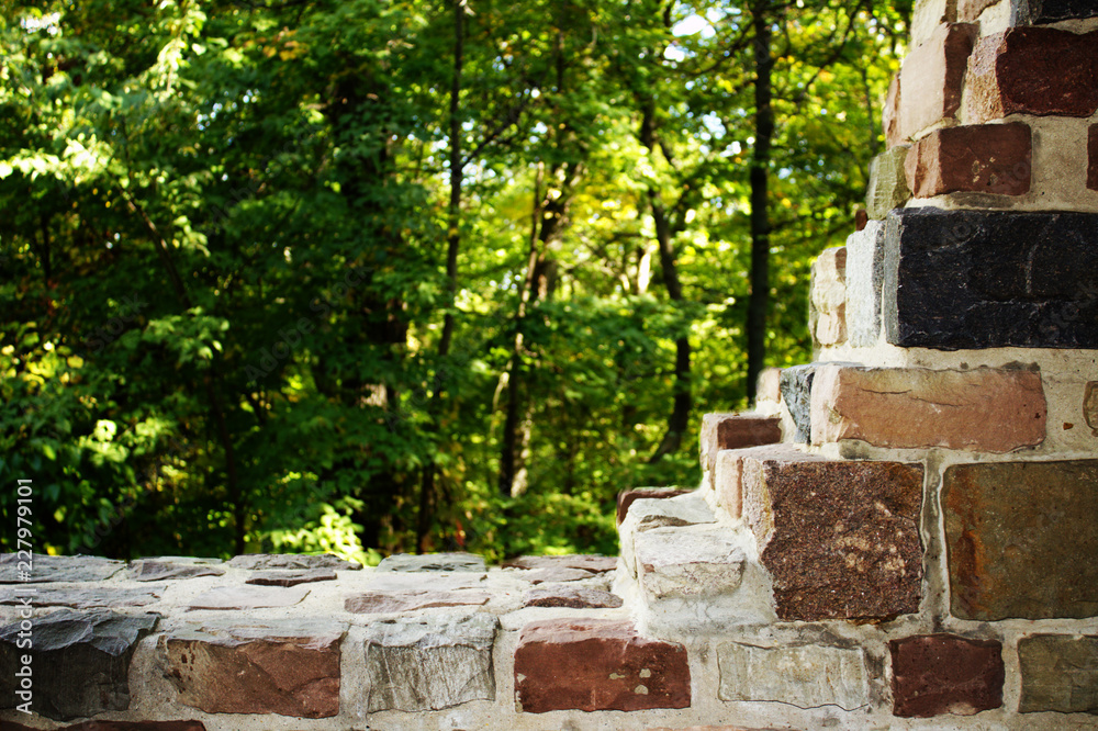 Beautifully Built Fieldstone Masonry Cut Away Wall Overlooking a Soft Glowing Yellow Green Forest