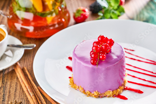 Small cake with red currants on white plate