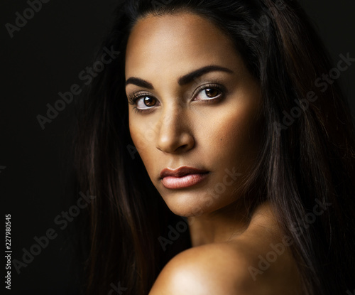 Young beautiful model in a closeup low key make up and hair style portrait shooting.