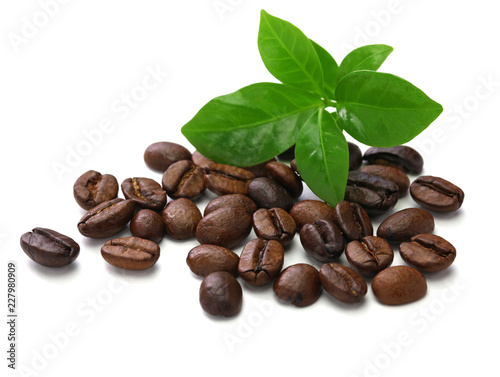 scattered roasted coffee beans and leaves on white background 