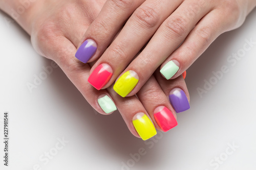 Bright summer rainbow moon manicure in red  yellow  mint  lilac  pink shades on square nails on a white background close-up