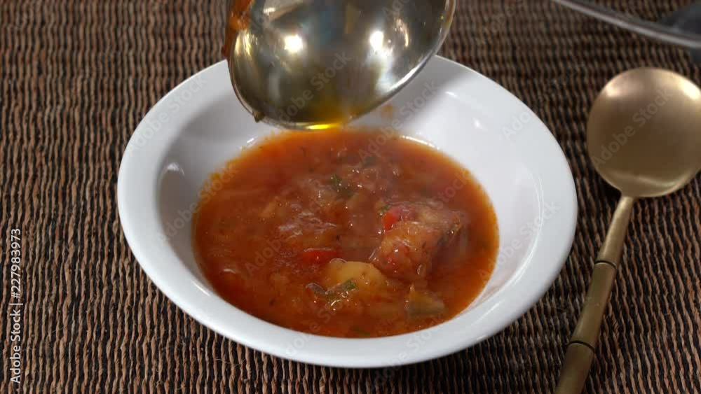 White plate with a homemade appetizing and tasty borsch. Red beetroot vegetable soup. Ukrainian and russian traditional red beet soup - borscht or borsch, close up