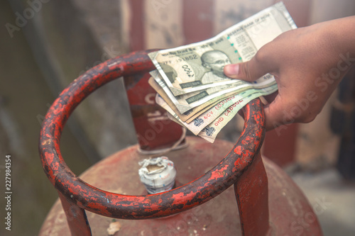 Canvas Print Man holding LPG gas cylinder and Indian rupee notes