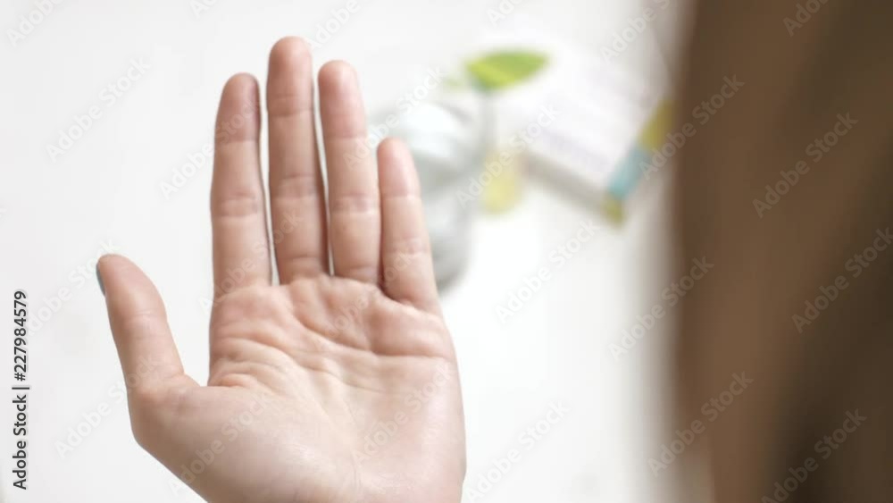 Close up of woman's hand holding pills Omega-3 fatty acids vitamin minerals in hand and taking glass of water Close up of woman's hand holding pills Omega-3 fatty acids vitamin minerals in hand and taking glass of water