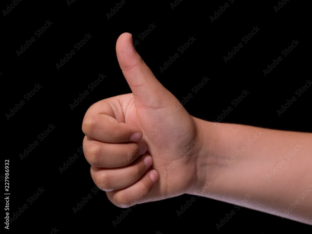 child hand showing ok. Thumbs up. Isolated on black background child hand showing ok. Thumbs up. Isolated on black background