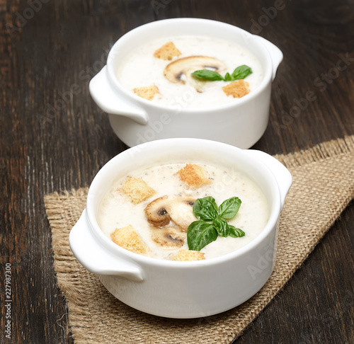 champignon soup with crackers on wooden background