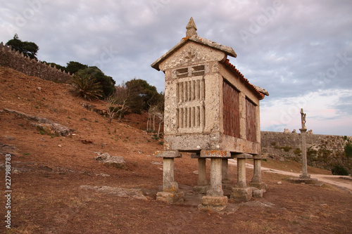 Photos hórreo gallego en Baiona con un cielo gris al atardecer