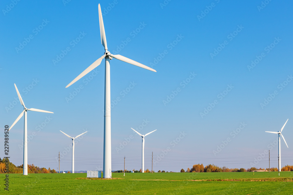 Wind turbines among a green field on a sunny autumn day Wind turbines among a green field on a sunny autumn day