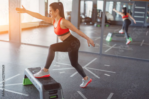 Adult sportswoman training with stepper photo