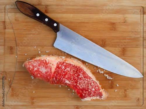 faca de churrasco e um pedaço de carne temperado com sal grosso.