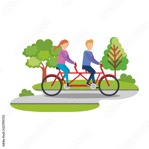 couple ridding bicycle tandem on the park