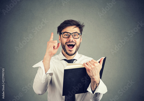 Excited man having idea while reading a book