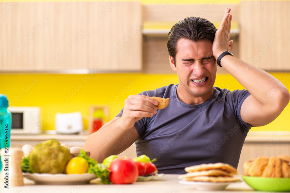 Man having hard choice between healthy and unhealthy food Man having hard choice between healthy and unhealthy food