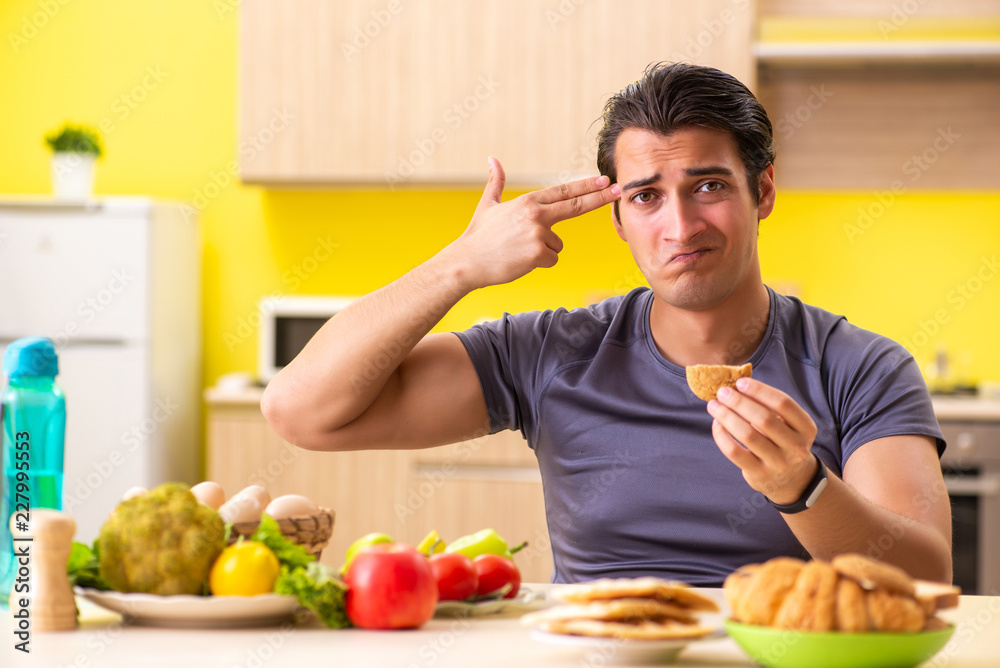 Man having hard choice between healthy and unhealthy food Man having hard choice between healthy and unhealthy food