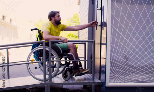 Young disable man in wheelchair going to a public restroom photo
