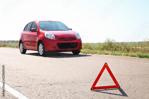 Emergency stop sign and broken car on background