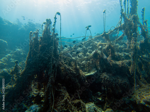 Discarded ghost fishing net causing damage to a coral reef and their habitat photo