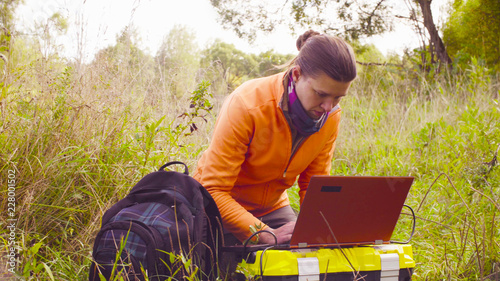 Woman scientist ecologist working on a laptop in the forest