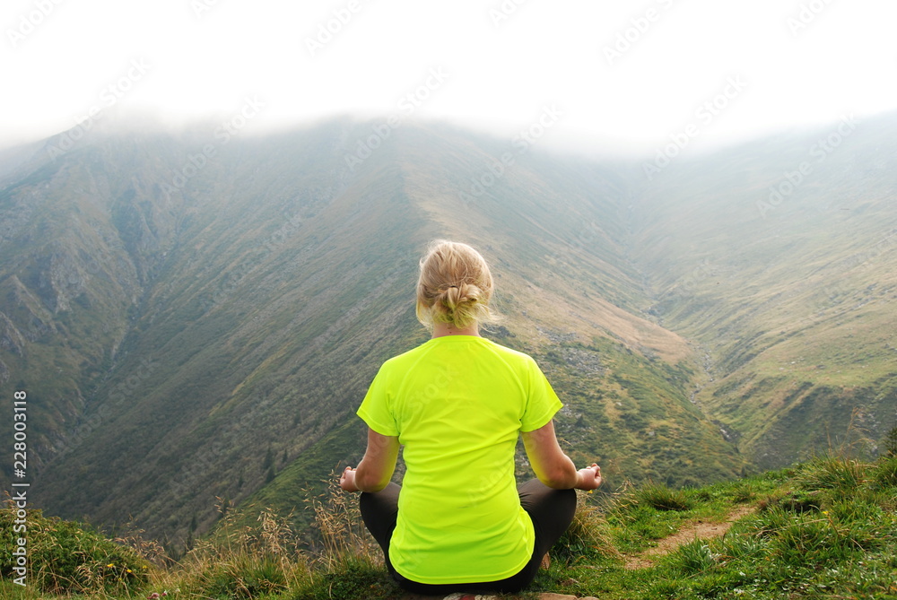 Naklejka premium A woman meditating in Carpathian Mountains, Transylvania, Romania