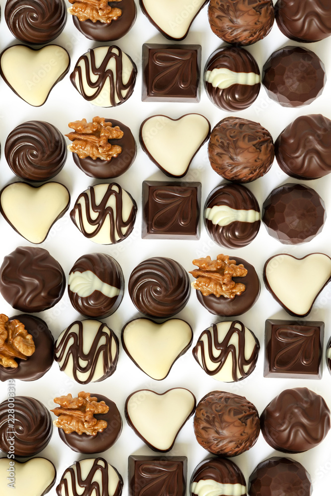 Assortment of chocolate candies from black, milk and white chocolate with nuts and marzipan Assortment of chocolate candies from black, milk and white chocolate with nuts and marzipan
