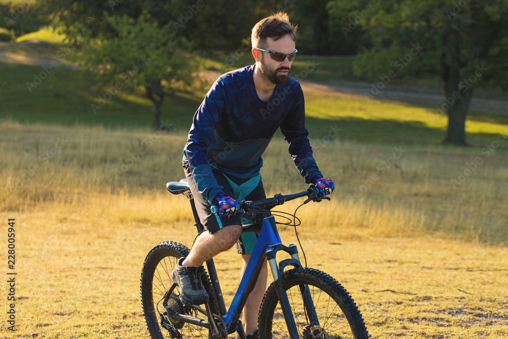 A cyclist rides the hills, Beautiful portrait of a guy on a blue bicycle