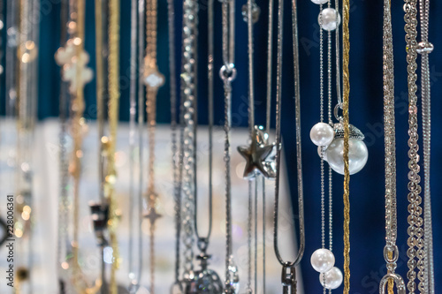 Stylish beautiful bijouterie hanging on the stand in the accessories store. Various Jewelry bijouterie show in retail shop window display showcase