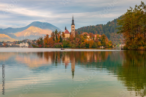 Bled lake and pilgrimage church with autumn mountain landscape background