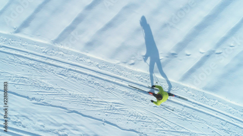 Canvastavla AERIAL: Flying above woman cross country skiing across large snow covered plain