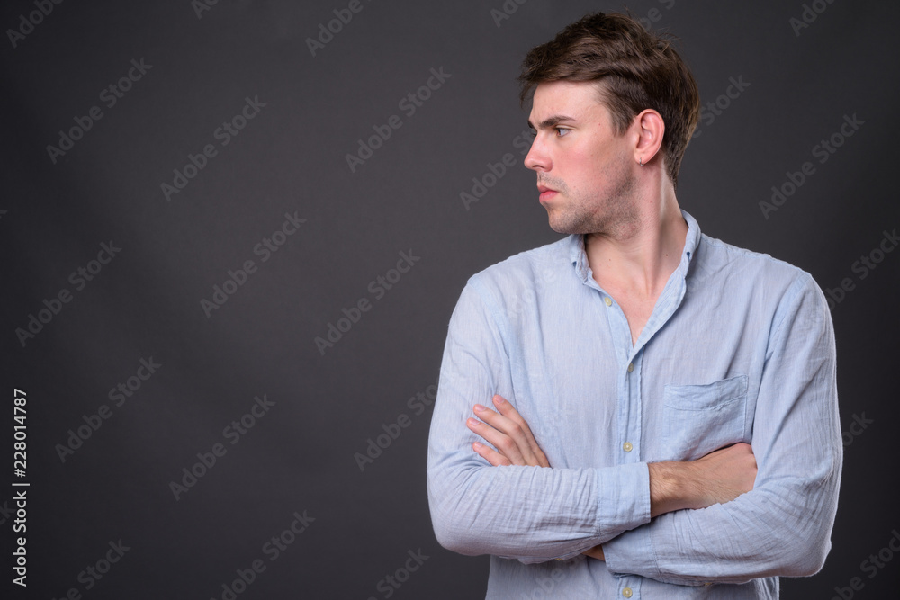 Studio shot of young handsome man against gray background Studio shot of young handsome man against gray background