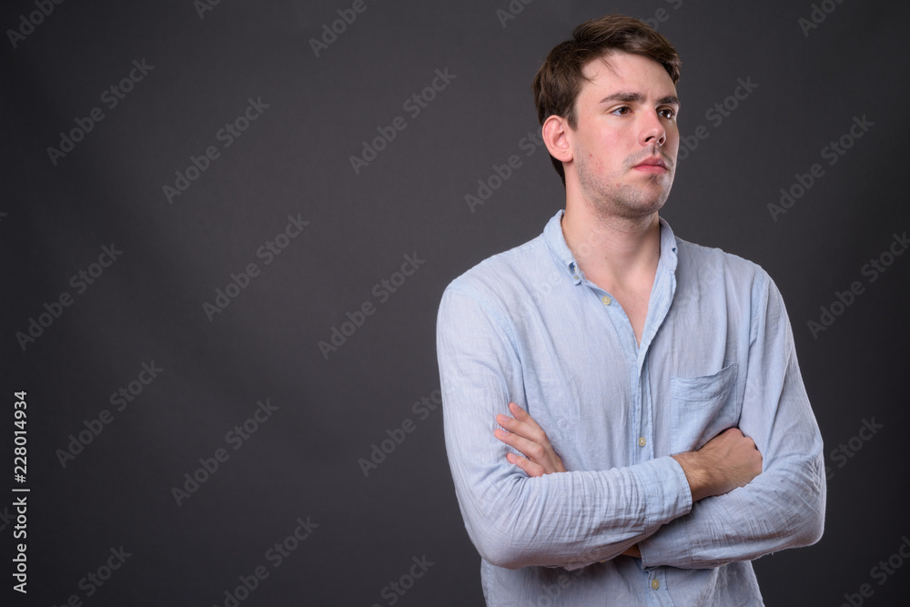 Studio shot of young handsome man against gray background Studio shot of young handsome man against gray background