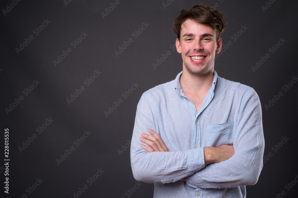 Studio shot of young handsome man against gray background Studio shot of young handsome man against gray background