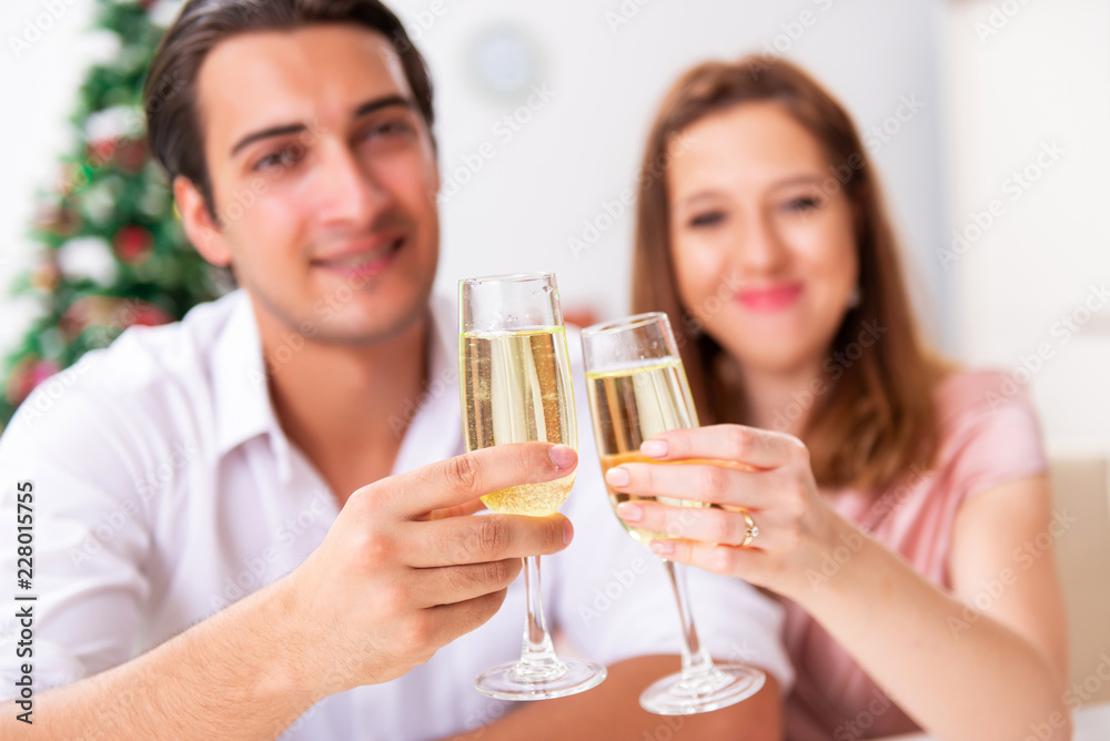 Young couple celebraring christmas with champagne