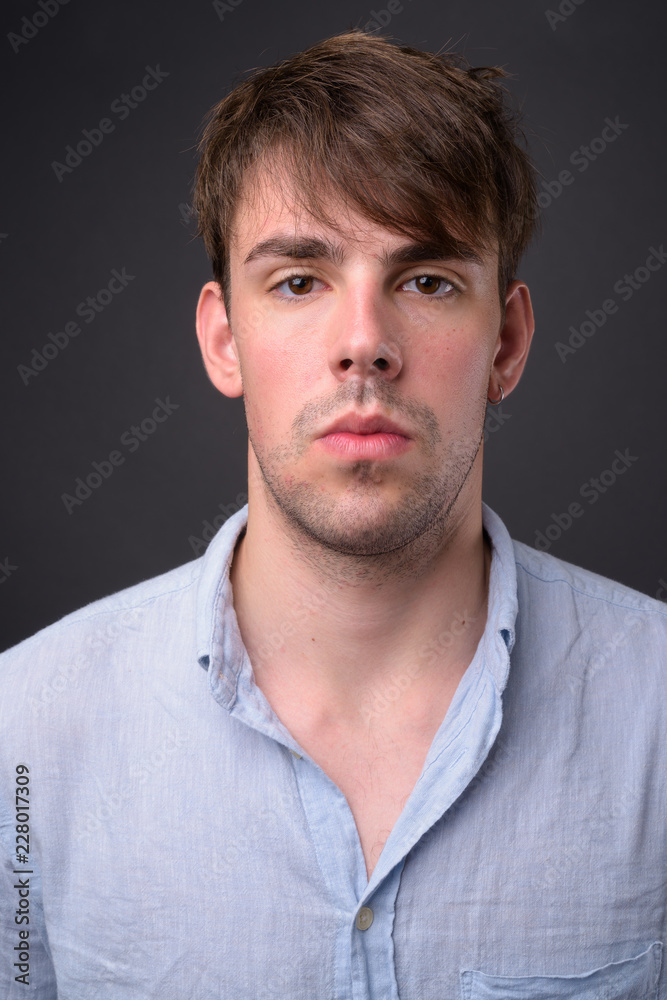 Fototapeta premium Studio shot of young handsome man against gray background