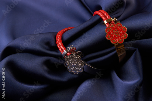 Pair of two Jewelery bijouterie rings with red leather on blue silk background with copy space, Beautiful precious women's jewelry, close-up