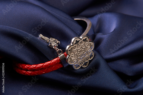 Pair of two Jewelery bijouterie rings with red leather on blue silk background with copy space, Beautiful precious women's jewelry, close-up